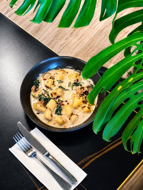 Soft gluten free gnocchi in creamy coconut garlic sauce with mushrooms and spinach