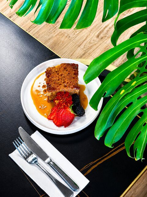 Vegan sticky date pudding with butterscotch sauce and fresh berries